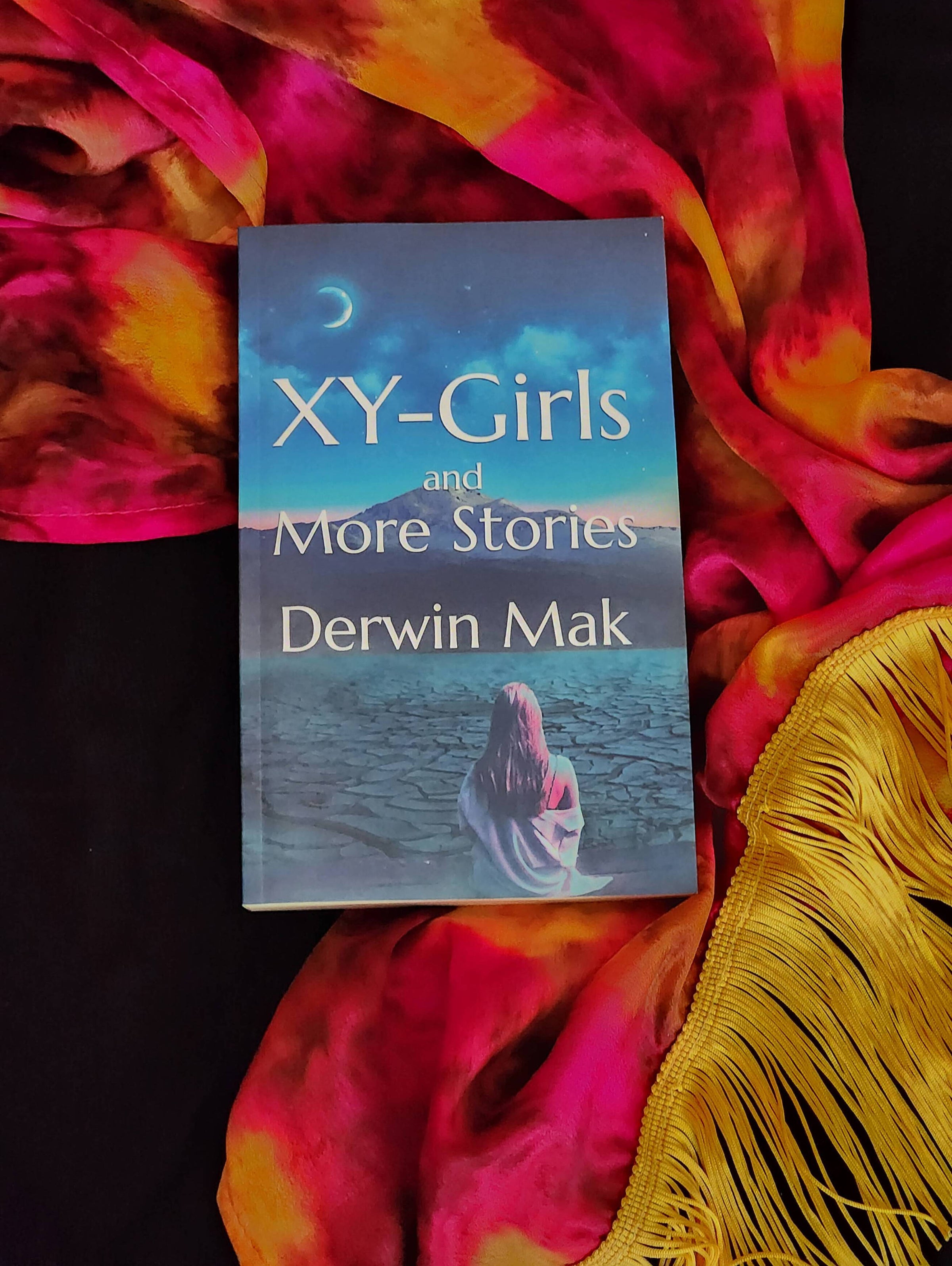 Photo of book against dark backdrop with red scarf