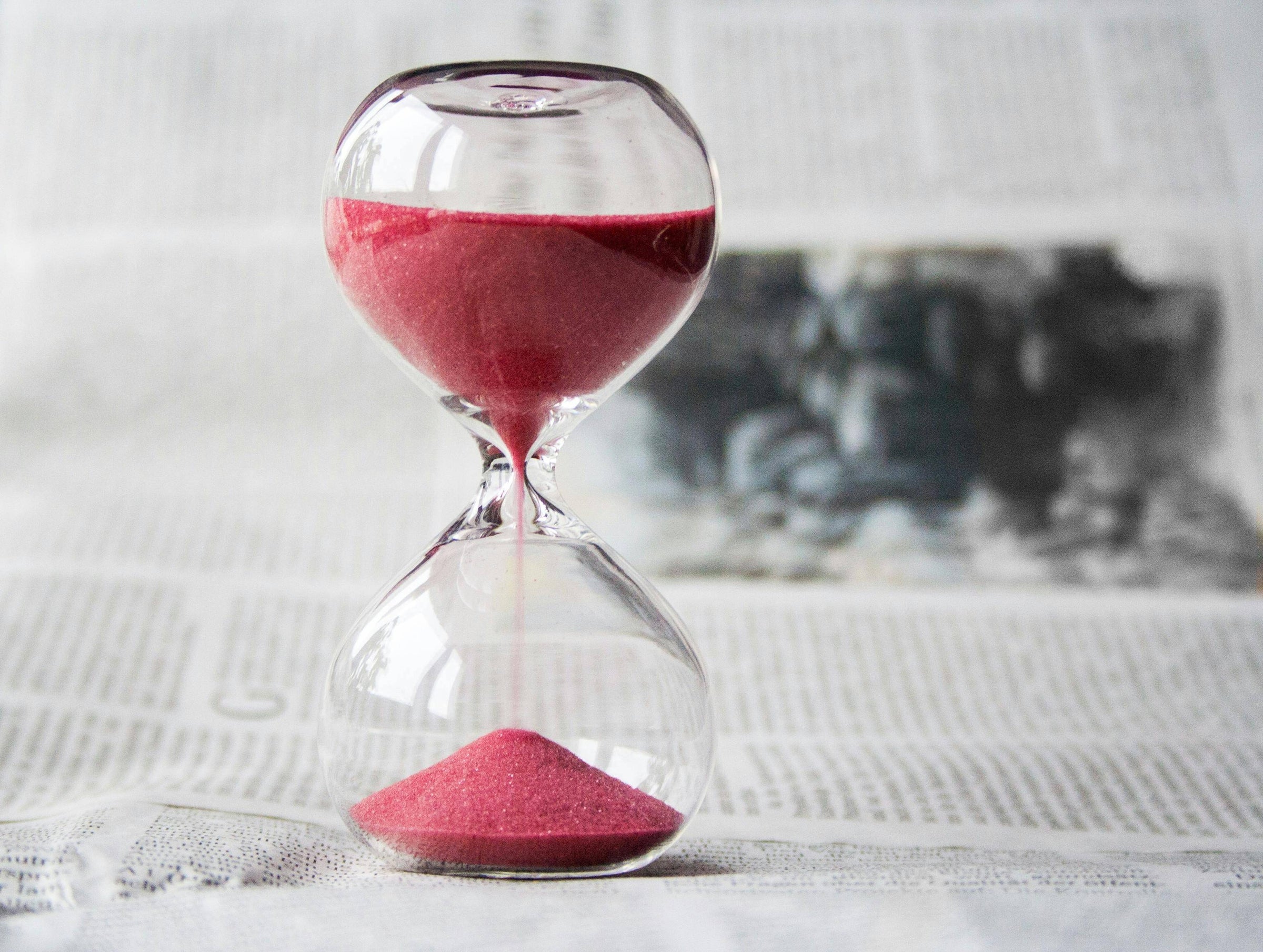 Stock photo of hourglass on newspaper